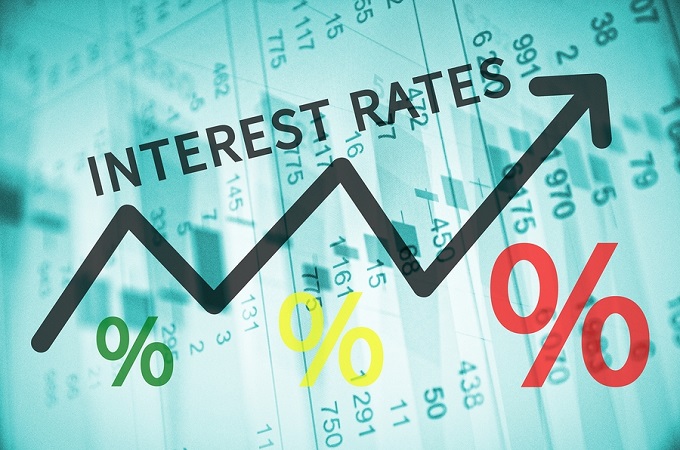 Text Interest rates on up trend arrow, with financial data visible on the background.